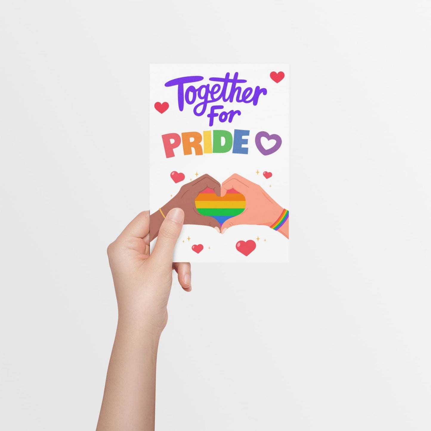 A hand holding a LGBTQ+ Pride celebration card with bold rainbow-colored text reading “Together for Pride.” Features a rainbow heart formed by two hands in a heart shape. A card to celebrate Pride and support the LGBTQ+ community.
