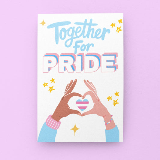 A Trans Pride celebration card with bold text in trans flag colors reading “Together for Pride.” Features a heart in trans flag colors formed by two hands in a heart shape. Designed to celebrate Transgender Pride with allies, family and friends. 
