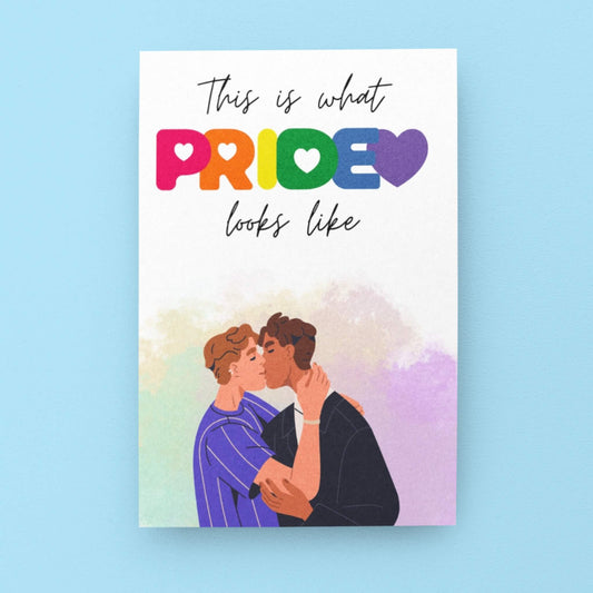 A vibrant colourful card, with a queer couple on the front, celebrating pride and kissing. Designed to celebrate LGBTQ+ pride. 