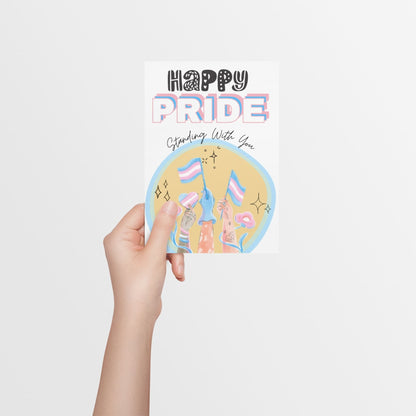 A card, with big bold font saying 'Happy Pride' in Transgender flag colours and a large Transgender flag in the centre of the card. Designed to support transgender people during Pride and show allyship. 